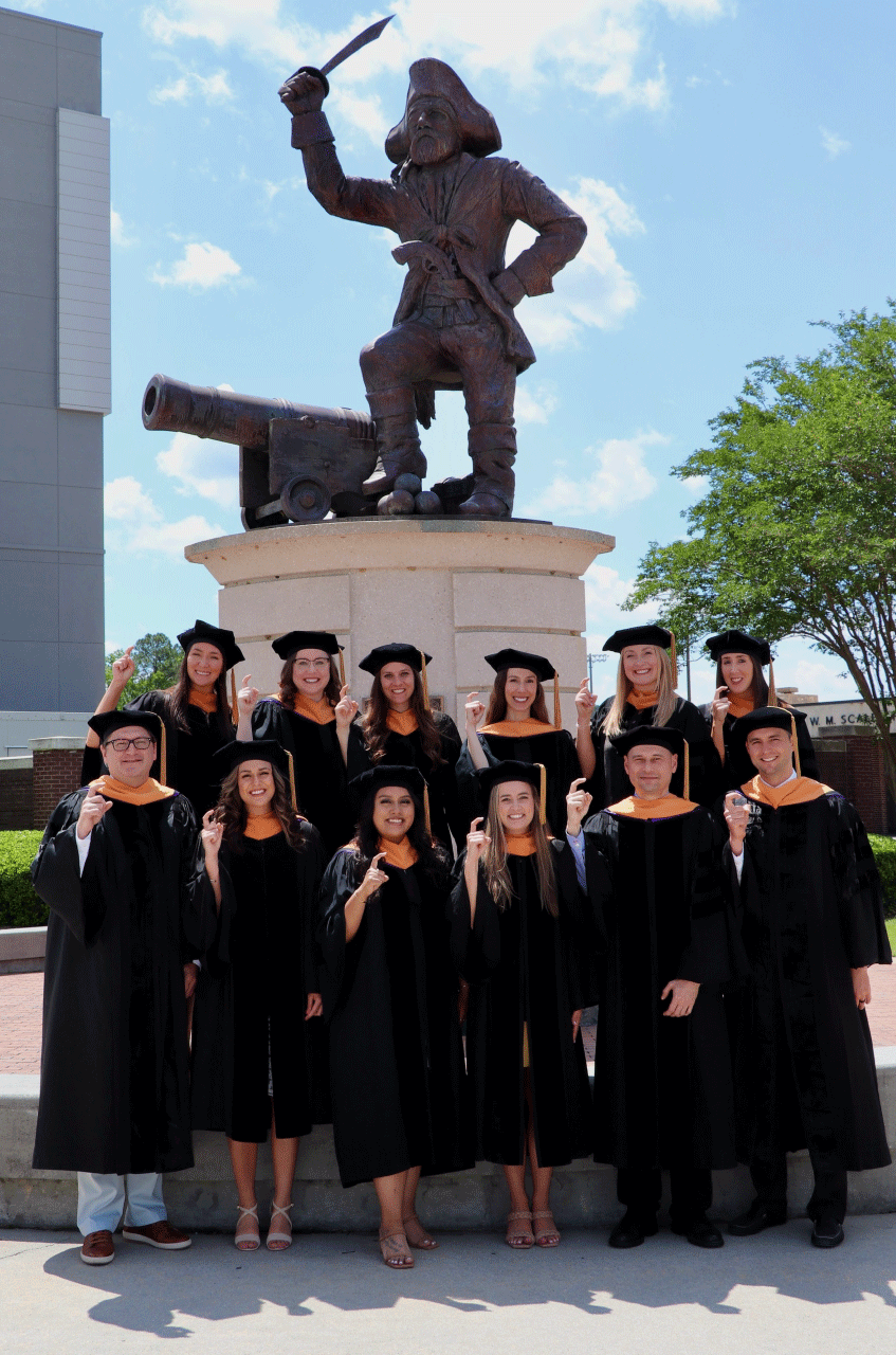 A group graduating students standing in front of the statue of Pee Dee the Pirate 