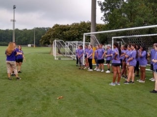 A group of students standing in front of soccer goal