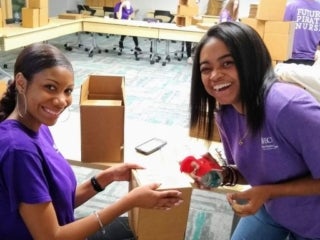Students packing boxes in an office