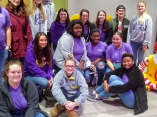 Students sitting around the statue of Ronald McDonald