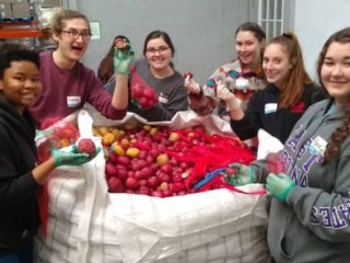 Students preparing a giant bag of potatoes