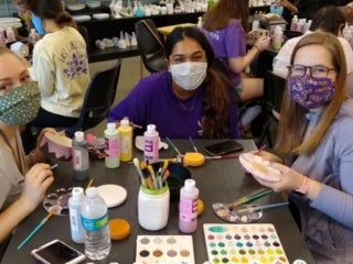 Students wearing masks sitting around the crafting table