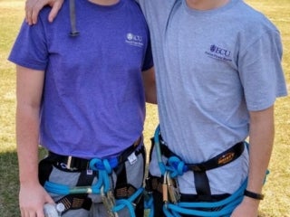 Two students wearing climbing gears