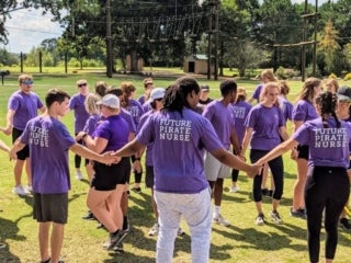Students holding hands in a circle