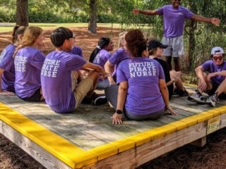 a group of student sitting on a wooden deck
