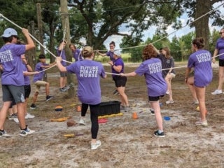 A group of students on a triangular rope course
