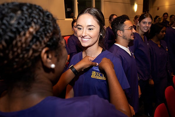 East Carolina University nursing students pin their peers with Lamp of Learning pins during a ceremony Sept. 8