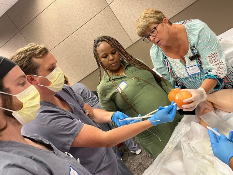 Midwifery students practice labor and delivery techniques.